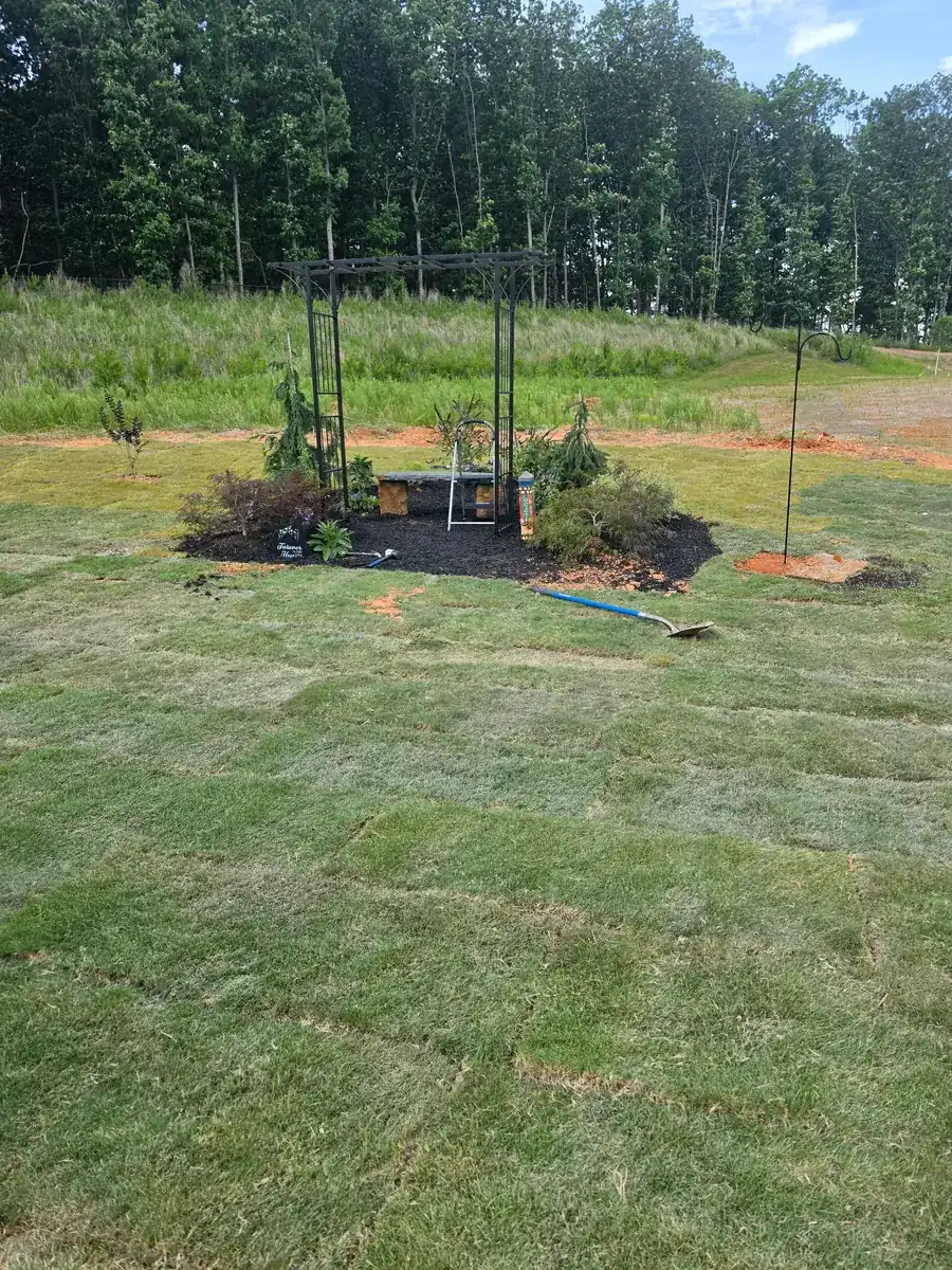 Paver patio installation in Concord, NC featuring a modern black metal privacy screen and planter wall